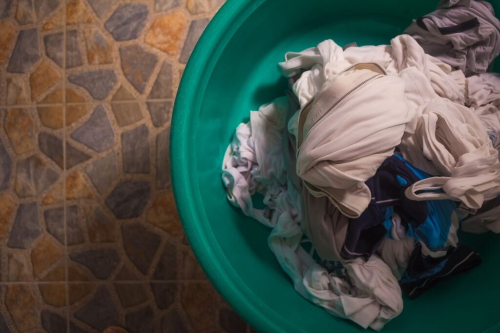 Laundry basket filled with clothes on a tiled floor