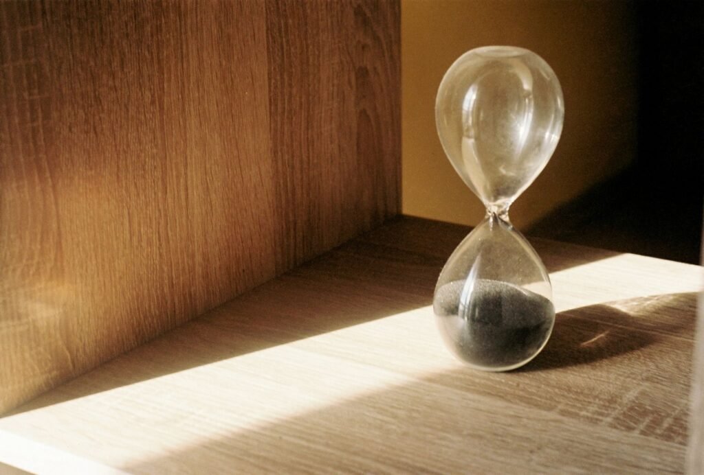 Glass hourglass with black sand on a wooden shelf, relevant to a Samsung Super Speed cycle taking too long issue