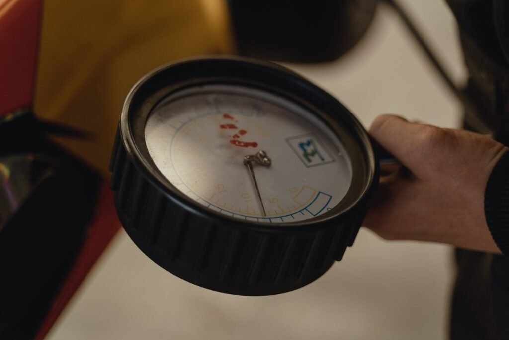 Hand holding a pressure gauge, relevant to the pressure sensor involved in a Samsung washer OC or OE overflow error