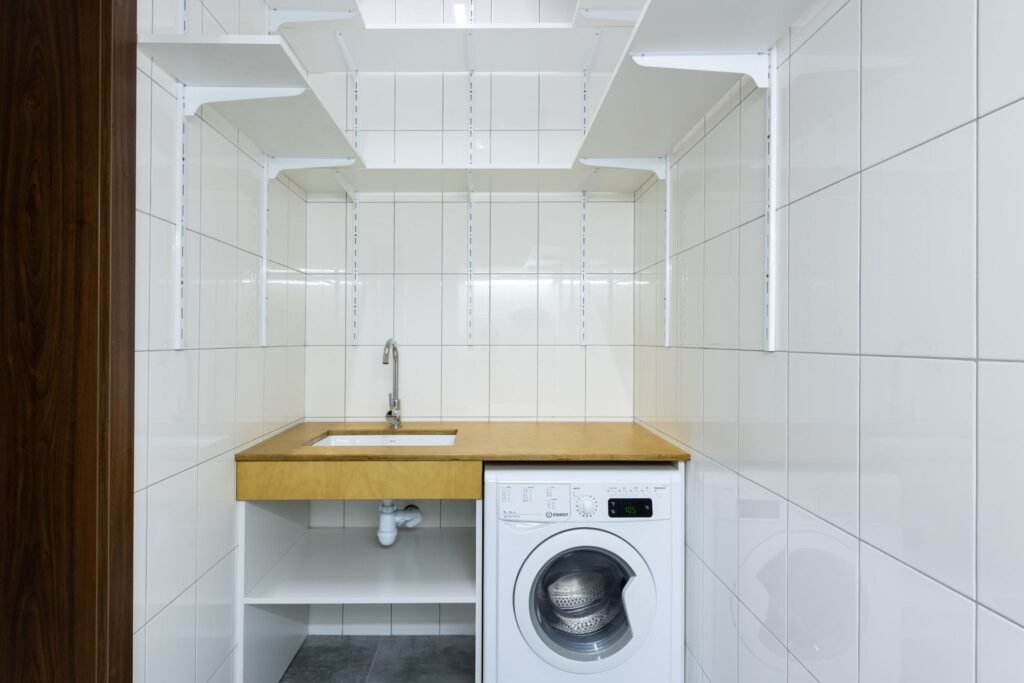 Modern laundry area with white tiled walls and a washing machine, relevant to a Samsung top load washer calibration failed issue