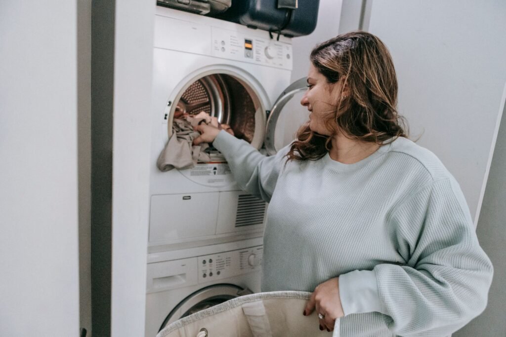 Woman loading clothes into a modern white washing machine, relevant to a Samsung Active WaterJet not working issue