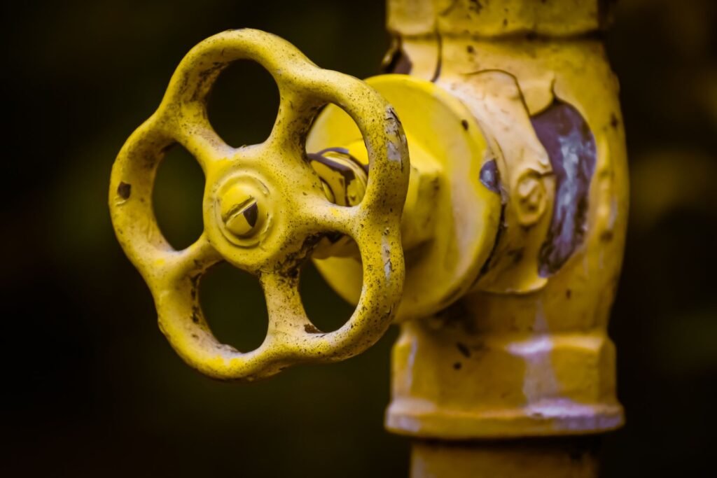 Close-up of a yellow shut-off valve, relevant to the first safe step for a Samsung washer LC or LE leak error