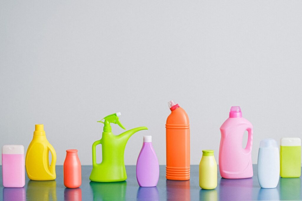 A row of household detergent and cleaning bottles, the over-supply behind most over-dosing
