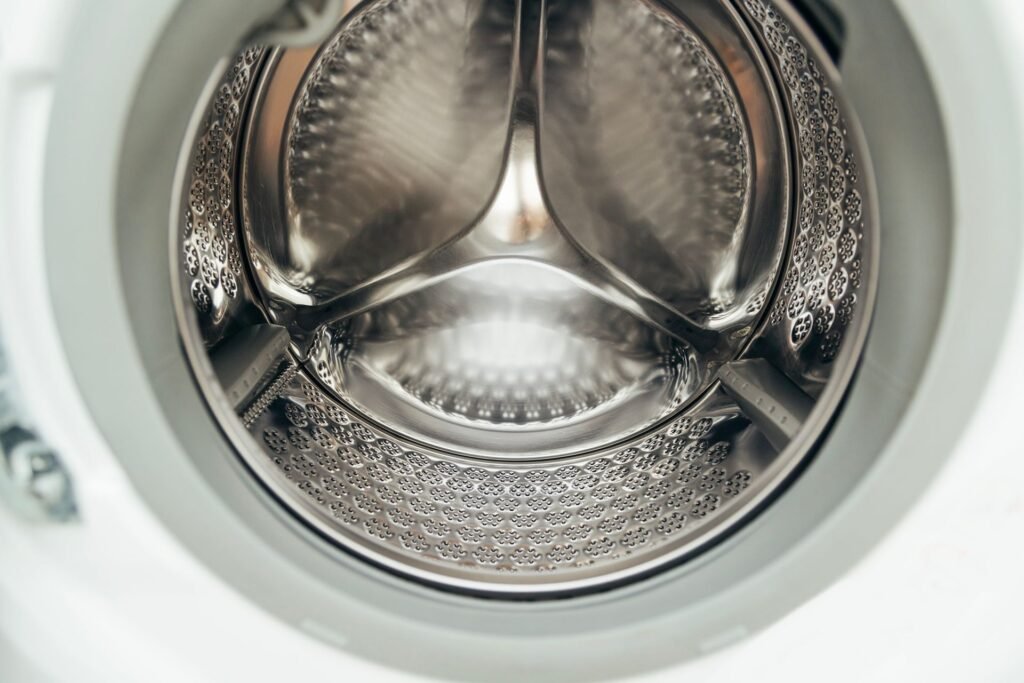 The stainless steel inner drum of a front-load washer, the surface a tub clean cycle flushes