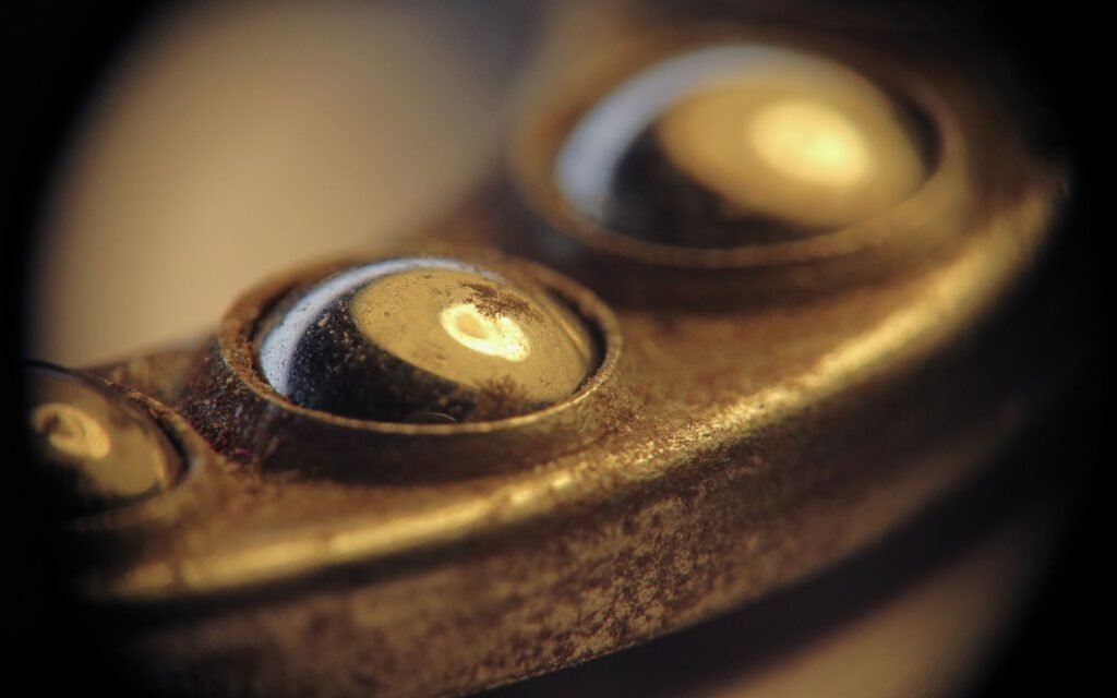 A close-up of worn metal ball bearings, the component that produces washing machine bearing noise as it fails