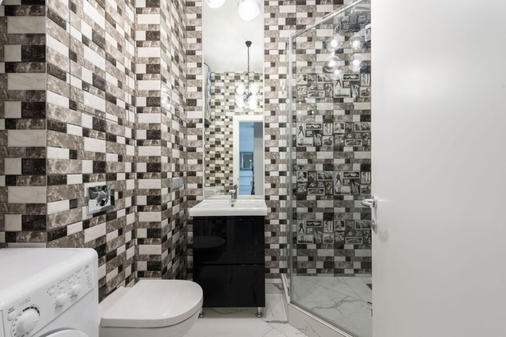 A washing machine beside a tiled bathroom floor, the kind of hard floor an overflowing washer floods first