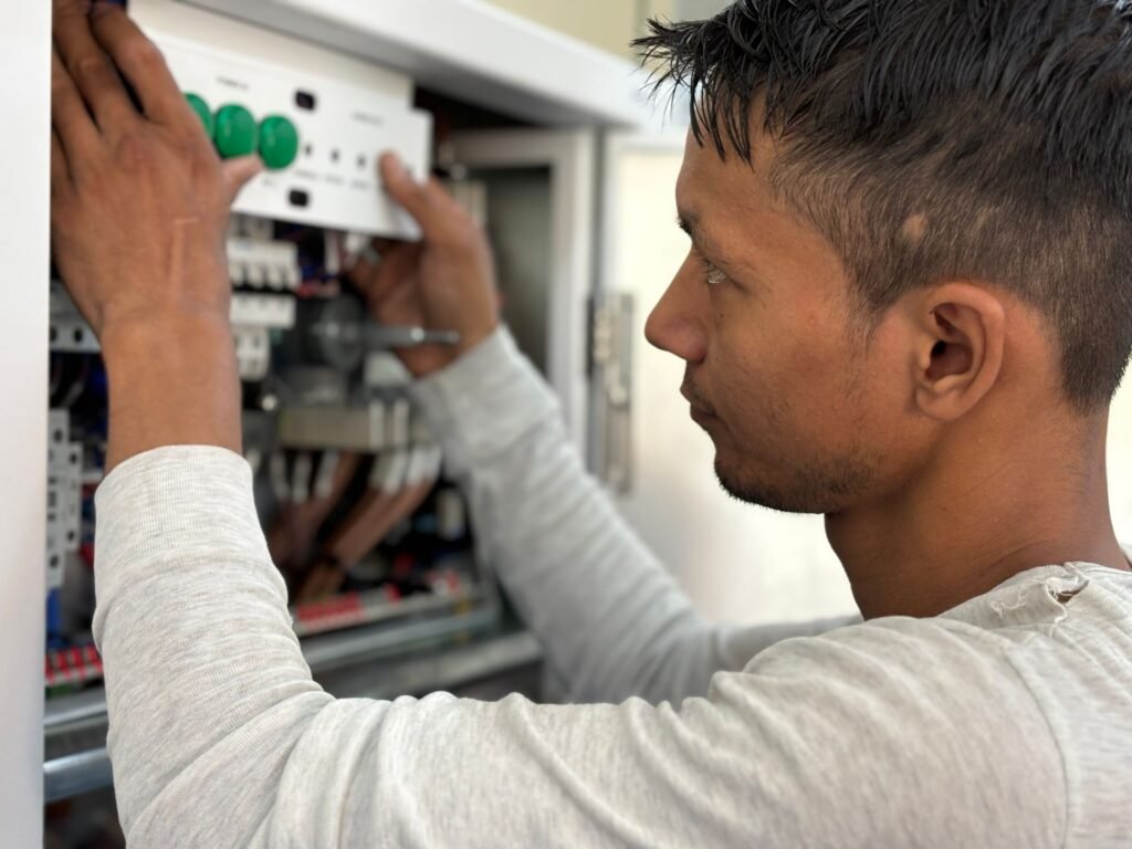 Electrician working at a residential circuit breaker panel to trace a repeatedly tripping laundry circuit