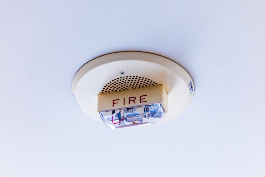 A ceiling-mounted fire alarm marked FIRE, the reason a burning smell from a dryer is never something to run through