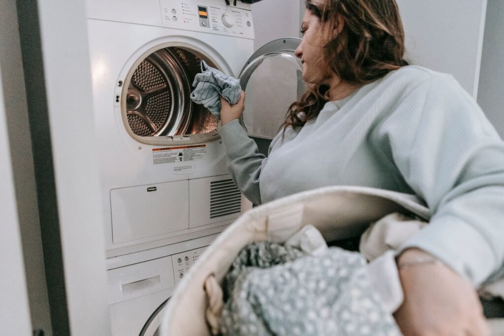 Person loading laundry into a machine in a bright home utility room, the routine that stops dead when a dryer will not start