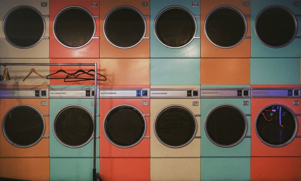 A row of older laundry machines in a laundromat, the kind of long service life a well-maintained dryer can reach