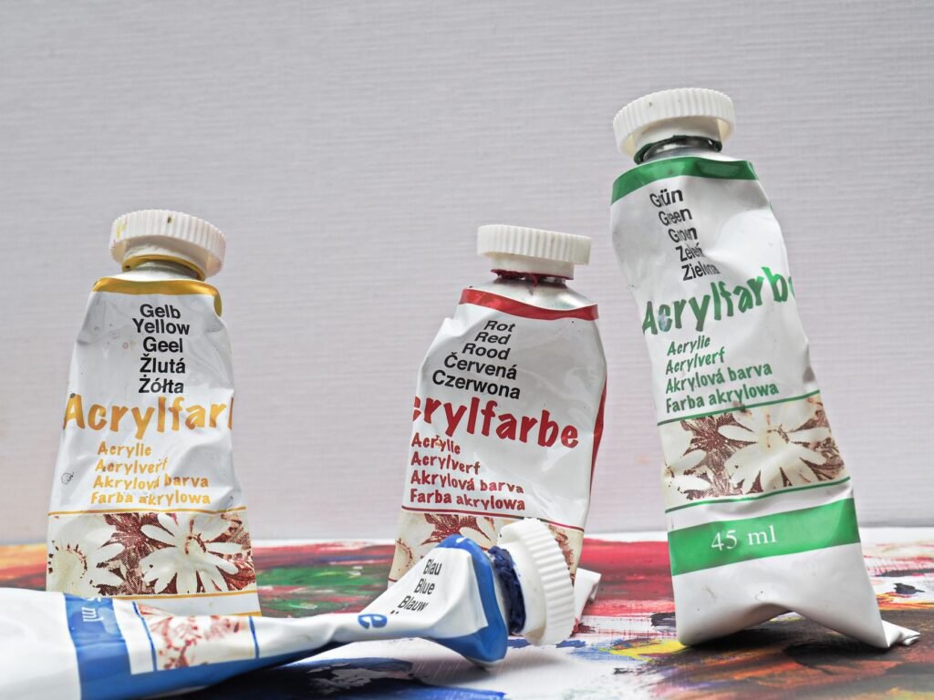 Tubes of acrylic paint lying on a canvas, the paint that cures into a plastic film on clothing