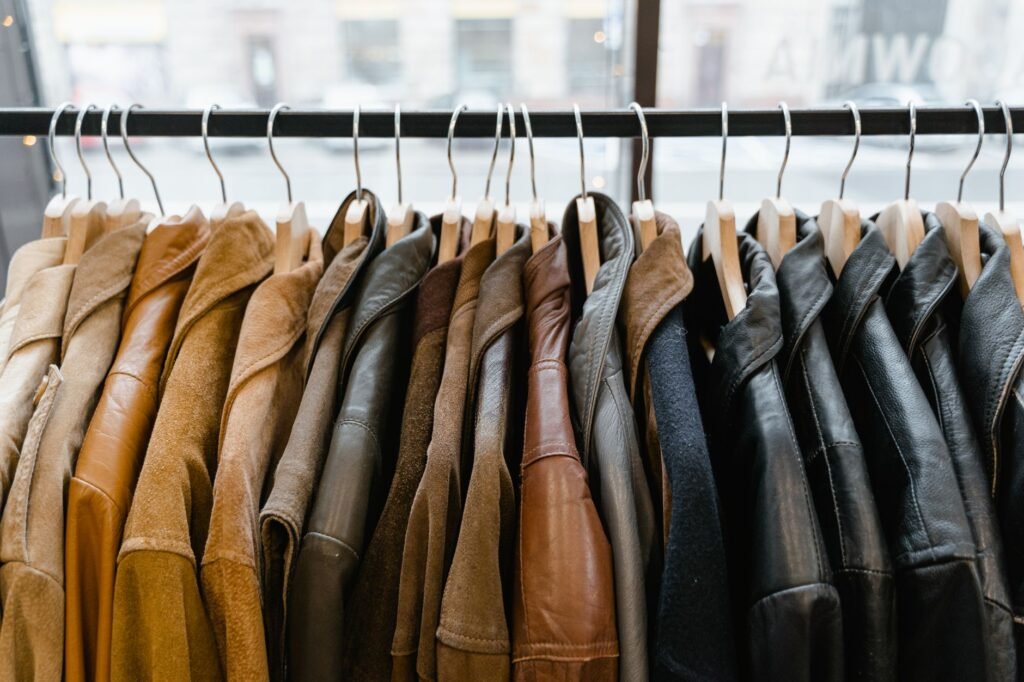 Row of leather and suede jackets hanging on a rail, showing the grain and finish that decide how each one is cleaned