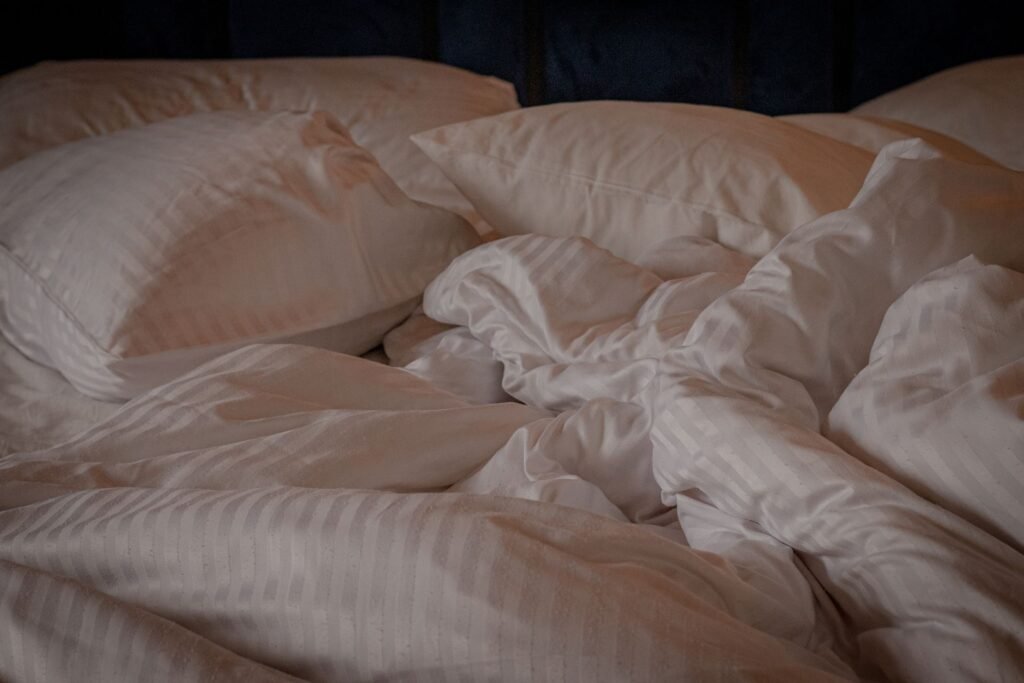 White pillows and a crumpled duvet on an unmade bed, the load most people never think to wash