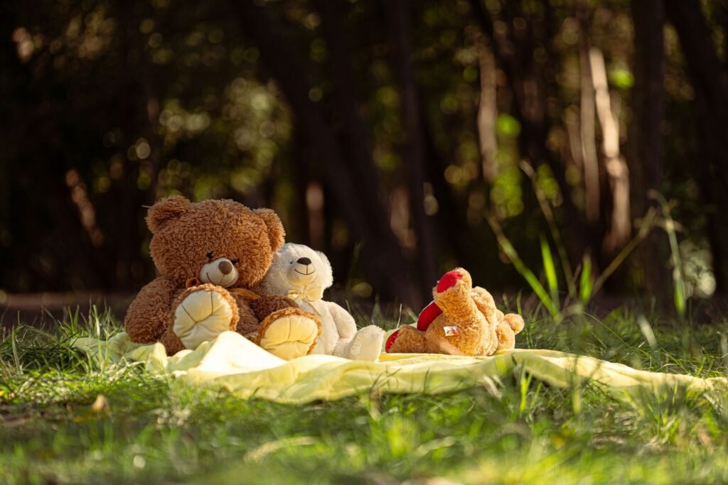 Three teddy bears drying outdoors on a blanket in sunlight after being washed