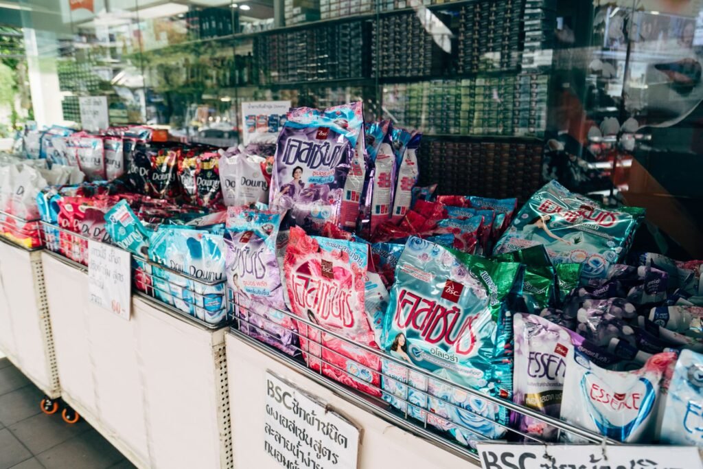 Laundry detergent in packets, pouches and boxes stacked on a shop display, where the choice of format is actually made