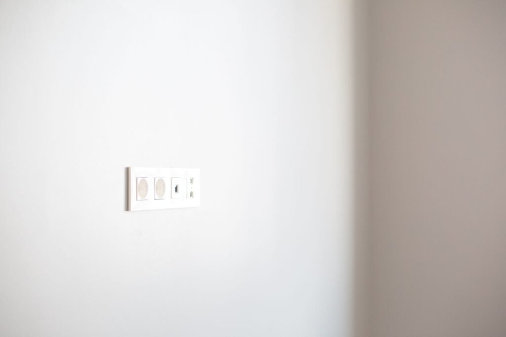 Modern grounded electrical wall socket on a white wall, the only connection a washing machine should use