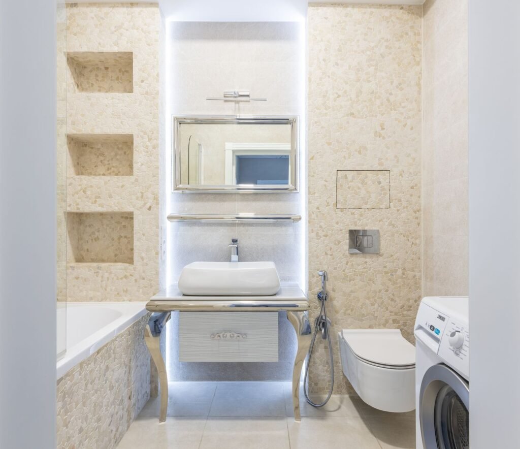 Washing machine installed against a tiled wall in a modern bathroom, where the drain hose run is decided