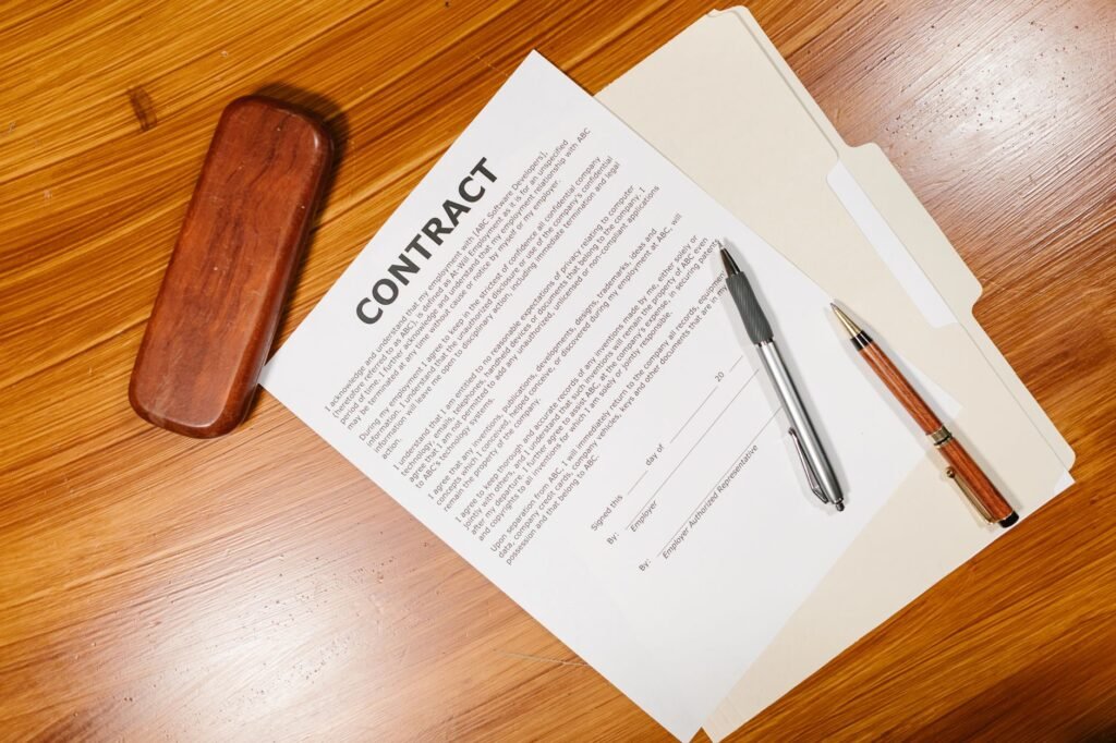 Printed contract with pens on a wooden desk, the extended warranty paperwork offered with a new washing machine