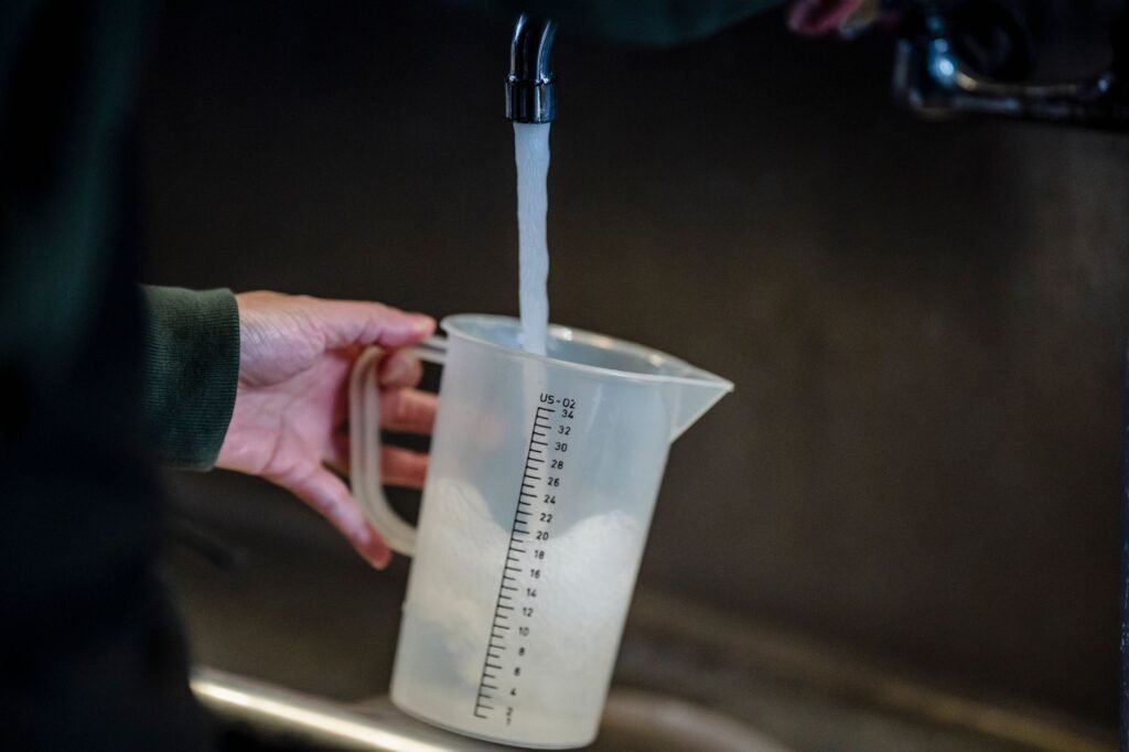 Jug held under a running tap, water continuing to pour in the way a washer does when a valve will not close