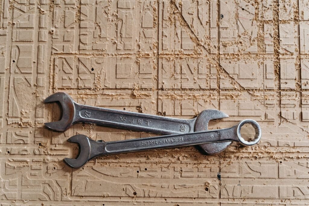Two metal spanners on a wooden surface, the tool needed to loosen washing machine shipping bolts on the rear panel