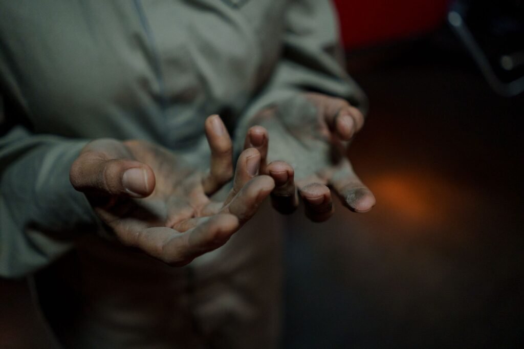 Worker in a grimy long-sleeved shirt with dirty hands, the heavily soiled clothing a prewash cycle is designed for
