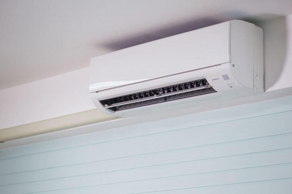 A white wall-mounted ductless mini-split head near a ceiling, the kind of unit whose drip tray a condensate pump for laundry rooms has to empty uphill