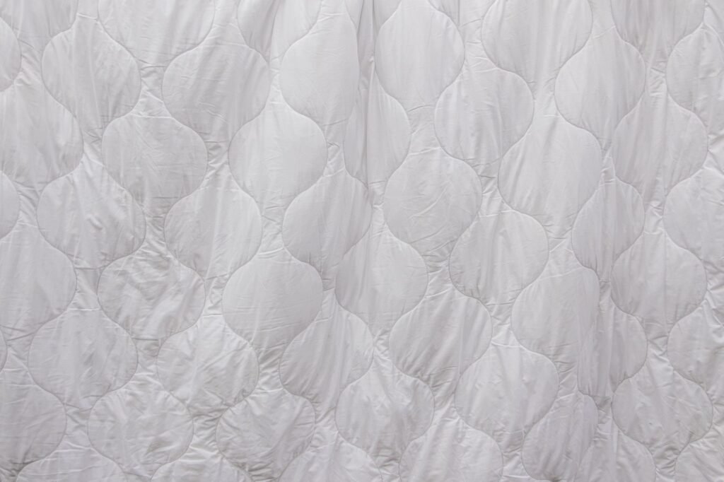 Close-up of a white duvet showing the curved stitched channels that hold the filling in place