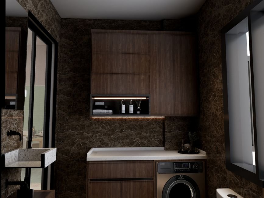 A single front-load washing machine built in under a pale stone counter in a dark marble bathroom with wood wall cabinets above it